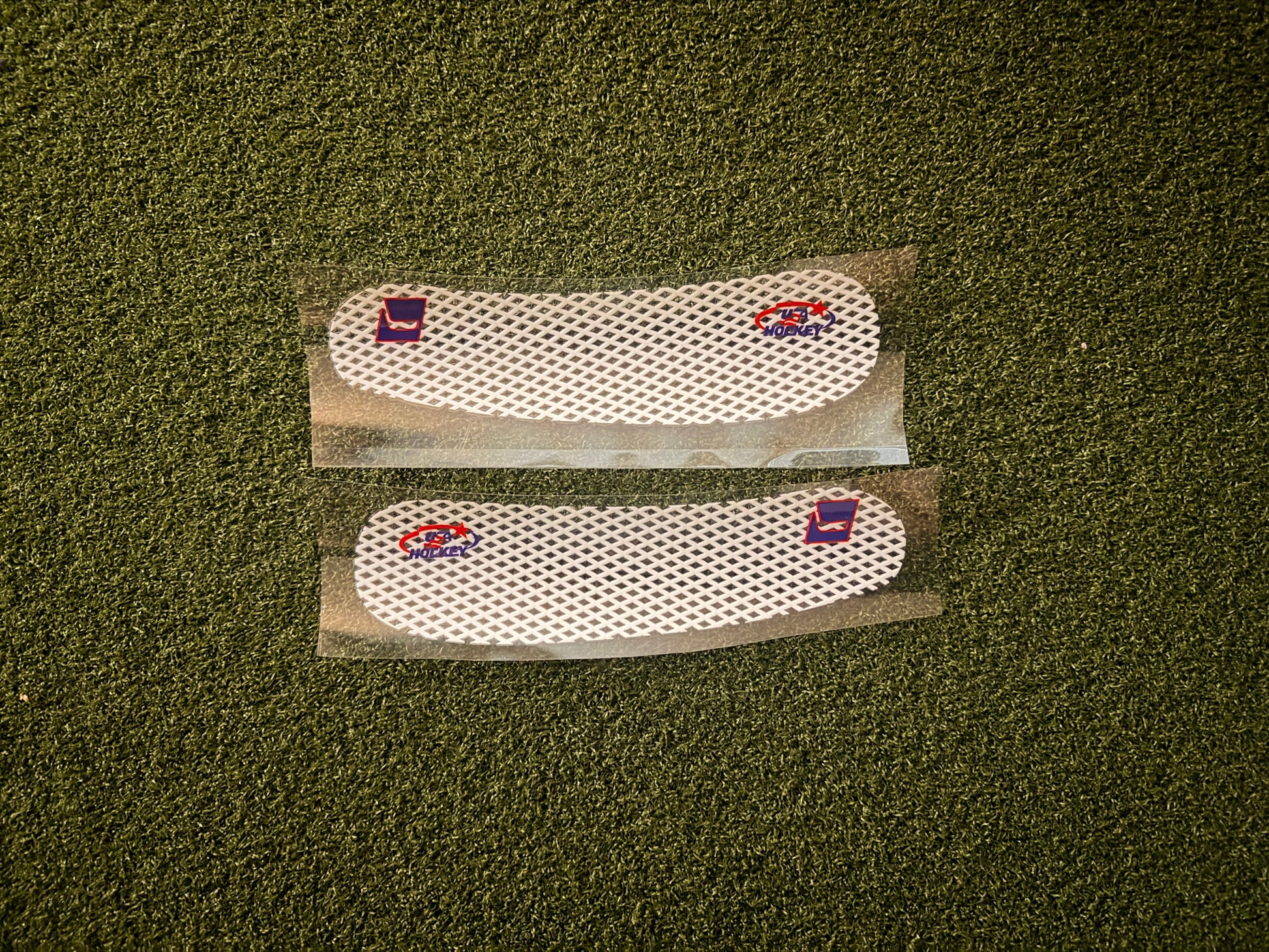 Two custom, white blade tape stickers with HKY IQ and USA Hockey logos