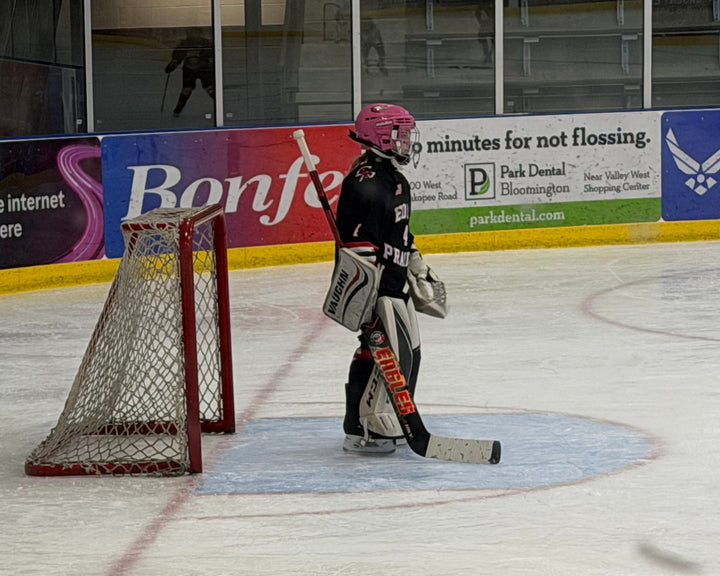an 8u player in goal with a custom HKY IQ Eden Prairie Eagles hockey stick