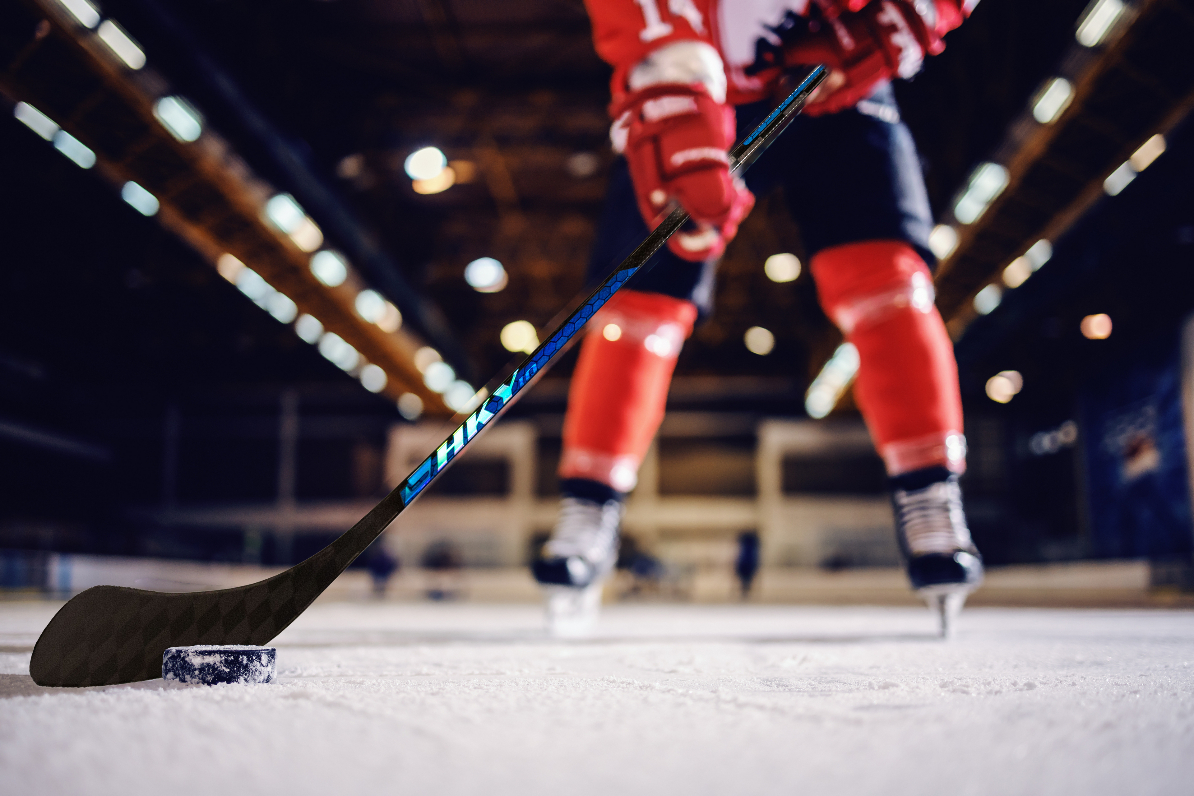 Simple black silhouette of a hockey stick on a plain white background, perfect for showcasing customizable hockey stick graphics or representing in-stock hockey sticks.